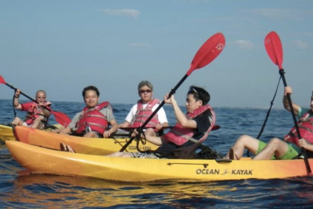 a group of people in a small boat in a body of water